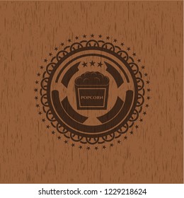 popcorn icon inside badge with wooden background