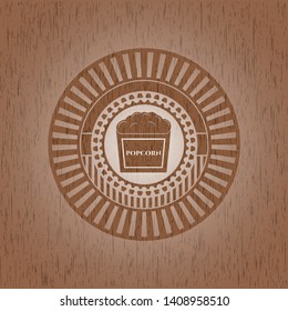 popcorn icon inside badge with wooden background