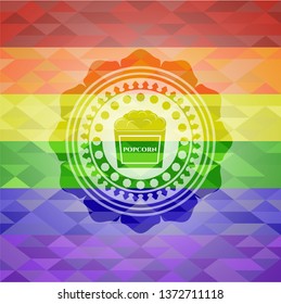 popcorn icon inside emblem on mosaic background with the colors of the LGBT flag