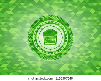 popcorn icon inside green emblem. Mosaic background