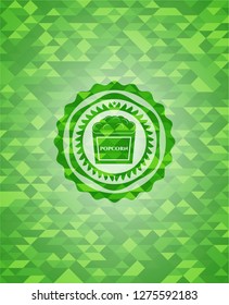 popcorn icon inside green emblem with mosaic background