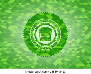 popcorn icon inside green emblem. Mosaic background