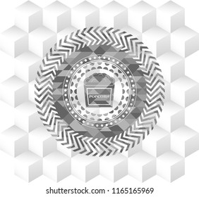 popcorn icon inside grey emblem with geometric cube white background