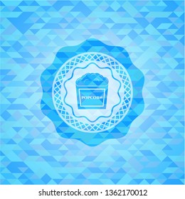 popcorn icon inside light blue emblem with triangle mosaic background