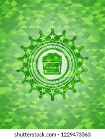 popcorn icon inside realistic green emblem. Mosaic background