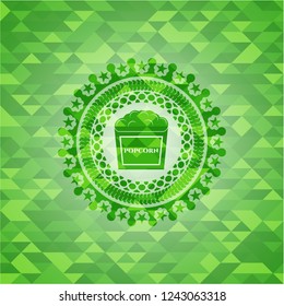 popcorn icon inside realistic green mosaic emblem