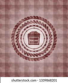 popcorn icon inside red emblem or badge with abstract geometric polygonal pattern background. Seamless.