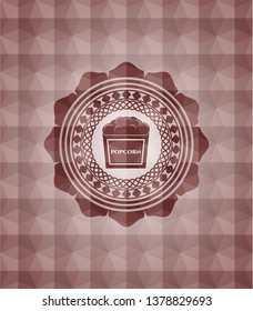 popcorn icon inside red emblem or badge with abstract geometric polygonal pattern background. Seamless.