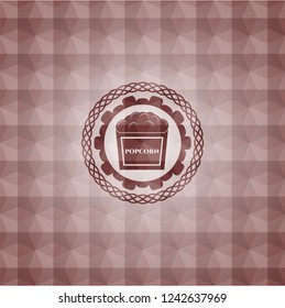 popcorn icon inside red seamless emblem with geometric background.