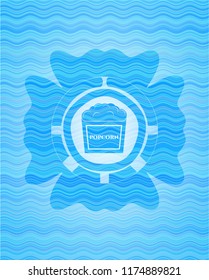 popcorn icon inside sky blue water wave emblem background.