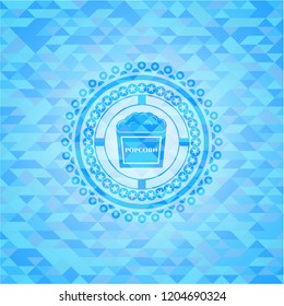 popcorn icon inside sky blue emblem with triangle mosaic background