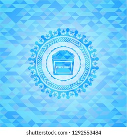 popcorn icon inside sky blue emblem with mosaic background