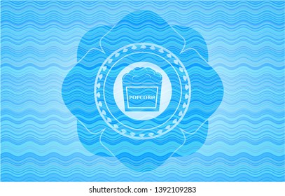 popcorn icon inside sky blue water style badge.