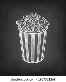 Popcorn in a striped cup. Chalk sketch on blackboard background. Hand drawn vector illustration. Retro style.