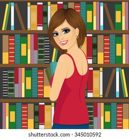 portrait of attractive brunette librarian woman in library holding books