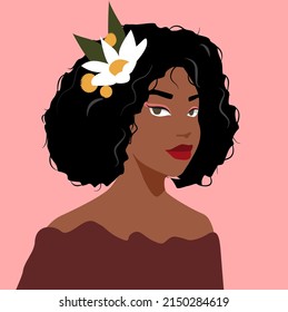 Portrait of a Beautiful African American girl with a chic pile of hair on her head, on a pink isolated background. Beautiful African curly hairstyle of a girl with a flower in her hair