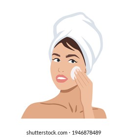 Portrait of a beautiful woman with a towel on her head cleaning her face. Skincare or spa concept