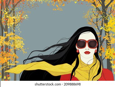 Portrait of a brunette woman with long flying in the wind hair on background with autumn trees