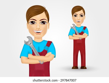 portrait of friendly young plumber dressed in work clothes holding a  wrench in crossed arms