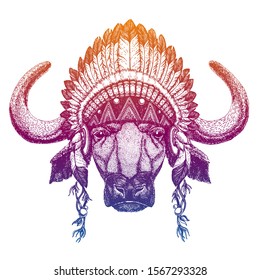 Portrait of vector buffalo, bull, ox, bison. Animal wearing traditional indian headdress with feathers. Tribal style illustration for little children clothes. Image for kids tee fashion, posters.