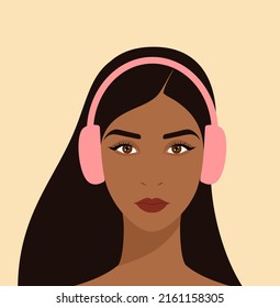 Portrait of a young beautiful woman with long brown hair and in pink headphones