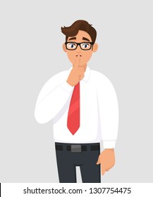 Portrait of young handsome businessman making shh gesture, keeping secret or asking silence with finger on lips. Keep quiet! Shh! Silence please! against gray/grey background in cartoon illustration.