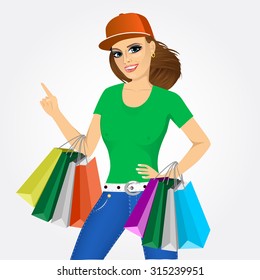 portrait of young pretty woman with baseball cap holding shopping bags and pointing up