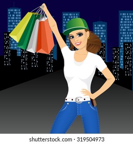 portrait of young smiling pretty woman with baseball cap holding shopping bags in front of night city