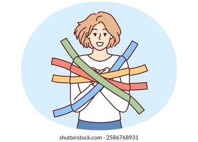 Positive girl smiles happily glued to wall with multi-colored adhesive tapes and is hostage. Metaphor of dependence and limited choice due to positive emotions and lack of critical thinking