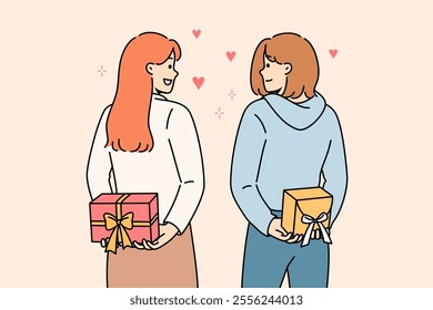 Positive girls hold gifts boxes behind their backs and look at each other lovingly, showing sympathy and affection. Young casual women exchange gifts on eve of march 8 or valentine day.