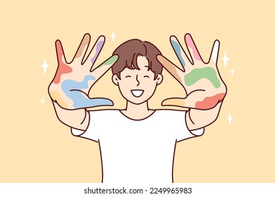 Positive guy stretches arms forward showing remains of multi-colored spots after drawing lesson. Creative boy in white t-shirt shows palms after experimenting with art. Flat vector illustration