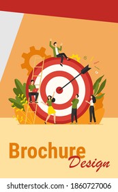 Positive tiny people sitting and walking near huge target with arrow isolated flat vector illustration. Cartoon business team achieving goal or aim. Marketing strategy and achievement concept