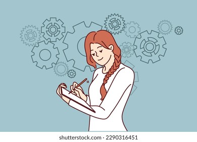 Positive woman is making checklist for improving business performance by making notes in notebook standing near gears. Concept of planning when doing business and drawing up strategic plans