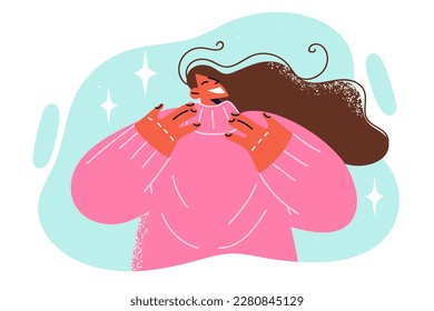 Positive woman smiles as she tries on warm sweater necessary for winter unheated rooms. Woman with long hair rejoices in comfortable sweater made of natural fabric that does not irritate skin 