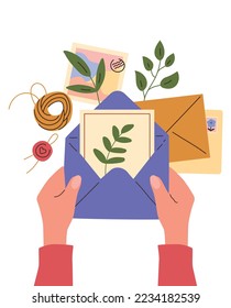 Postal envelopes in hands. Human arms write letters and sign postcards. Table top view. Sending invitations. Wax seals or postage stamps. Receive post correspondence