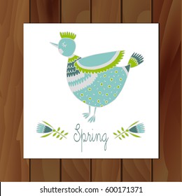 Postcard with a funny chicken on a wooden background.Blue bird in a folk style.Freehand drawing