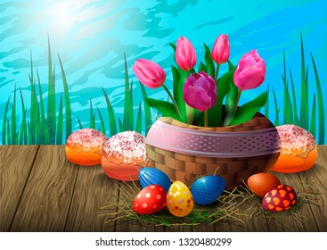 Postcard with tulips in a wicker basket, Easter eggs and cupcakes on a wooden table against the background of grass and sky. Beautiful greeting card or banner for Easter.
