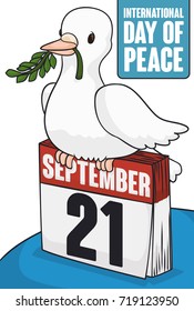 Poster with cute dove over a loose-leaf calendar with reminder date, holding a olive branch in its beak for International Day of Peace celebration in September 21.