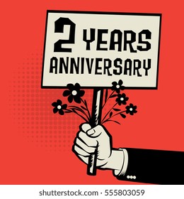Poster in hand, business concept with text 2 years anniversary, vector illustration.