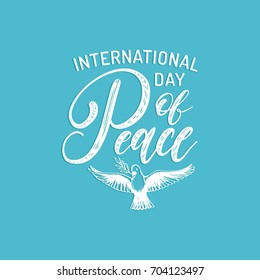 Poster with hand lettering of International Day of Peace. Vector hand drawn illustration of dove with a palm branch on blue background. Holiday card with calligraphy.