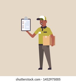 postman in uniform holding cardboard parcel box and receiving form clipboard african american courier express delivery service concept flat full length