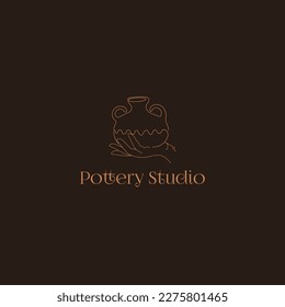 Pottery Studio Logo. Hand drawn pot on the hand on the dark background.
