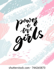 Power to the girls. Feminism slogan for apparel and posters. Black brush calligraphy on white background with painted stains of pink and blue.