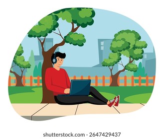 Practice positive thinking concept. A cheerful young man sitting outdoors under a tree, enjoying music with headphones, using a laptop amidst a peaceful park setting surrounded by trees.