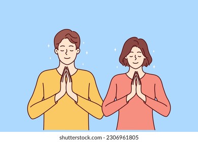 Praying man and woman fold palms in front of chests for joint prayer and religious ritual. Religious areni and girl with smile pray to god asking almighty for help in solving problems