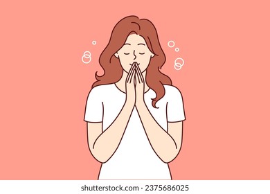 Praying woman performs meditation or religious ritual to purify thoughts and get rid of bad emotions. Casual girl stands with eyes closed and does meditation to achieve balance between body and soul