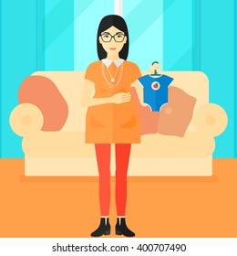 Pregnant woman with clothes for baby.