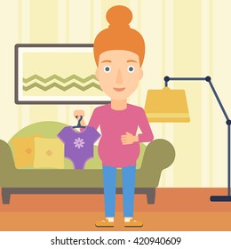 Pregnant woman with clothes for baby.