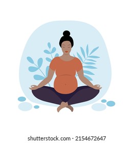Pregnant woman doing yoga, sitting in lotus position.