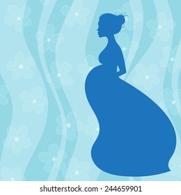 Pregnant woman in long dress on blue floral background